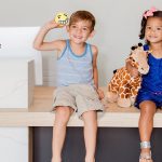 two kids smiling at the dentist office counter